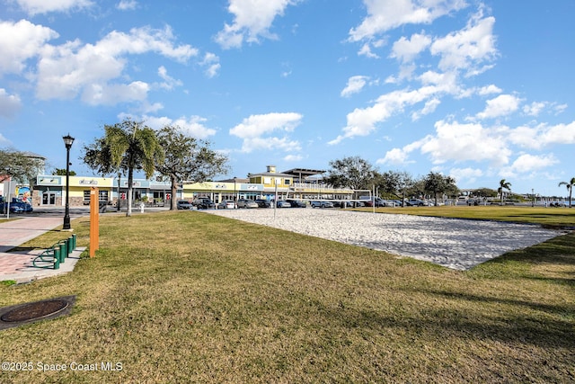 view of property's community featuring volleyball court and a lawn