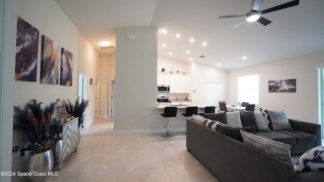 living room featuring high vaulted ceiling, ceiling fan, and light tile patterned flooring