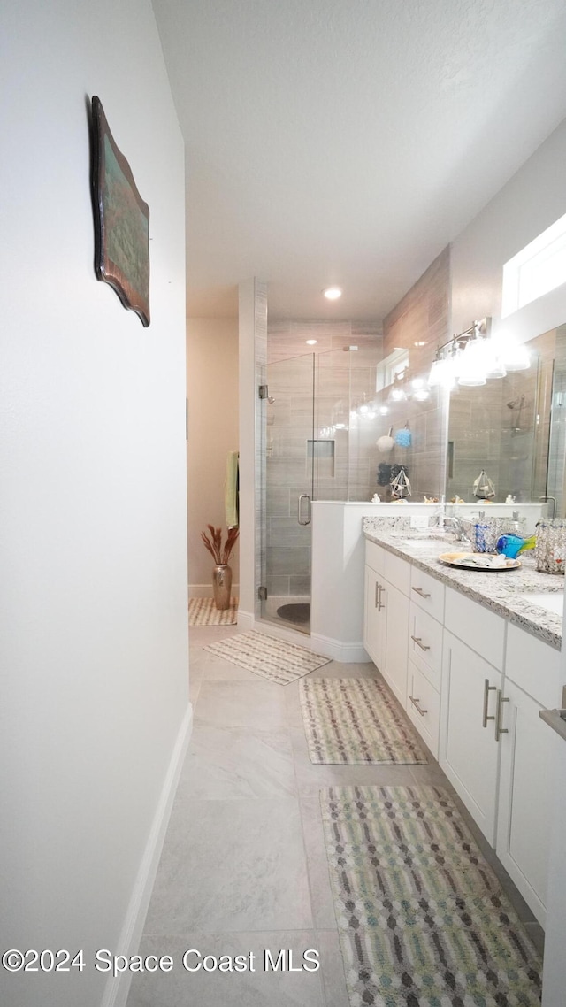 bathroom with tile patterned floors, vanity, and a shower with shower door