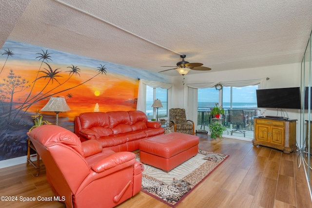 living room featuring a textured ceiling, hardwood / wood-style flooring, and ceiling fan