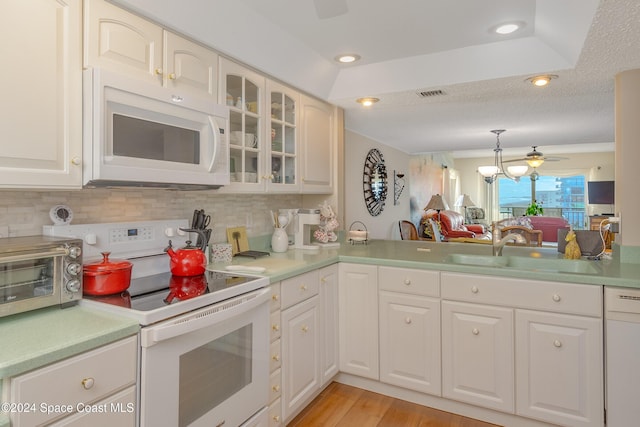 kitchen with glass insert cabinets, white appliances, light countertops, and visible vents