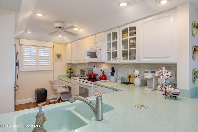 kitchen featuring glass insert cabinets, white appliances, light countertops, and white cabinetry