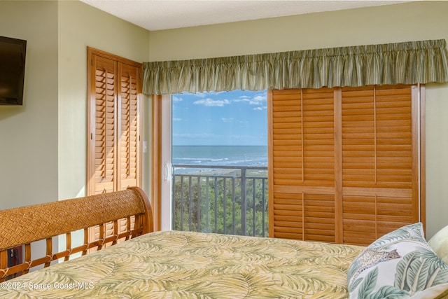 bedroom featuring a closet, a water view, and multiple windows