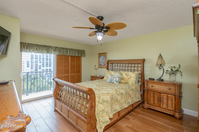 bedroom with access to exterior, ceiling fan, a textured ceiling, light wood-type flooring, and baseboards