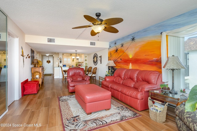 living room featuring ceiling fan, hardwood / wood-style floors, and a textured ceiling