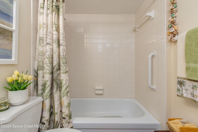 bathroom with a textured ceiling, shower / bath combo, and toilet