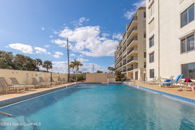 community pool featuring a patio area and fence