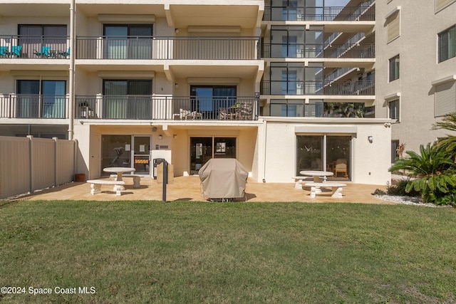 back of property with stucco siding, a patio area, and a yard