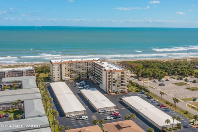 drone / aerial view with a water view and a beach view