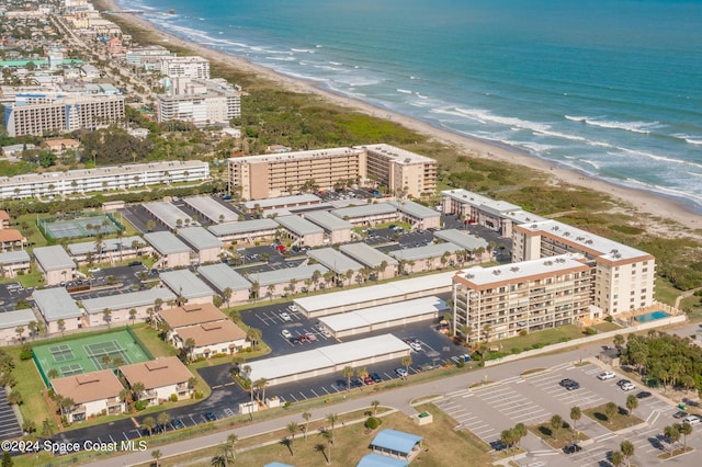 drone / aerial view with a water view, a view of the beach, and a city view