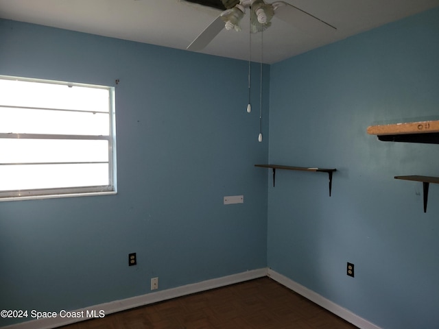 unfurnished room with dark parquet floors and ceiling fan