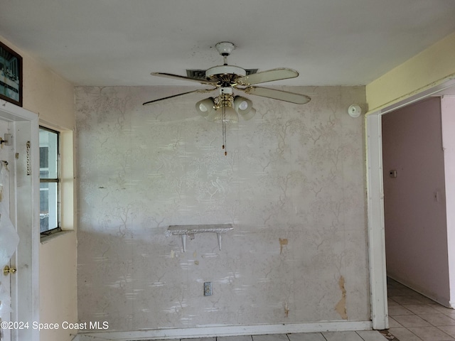 spare room featuring ceiling fan and light tile patterned floors