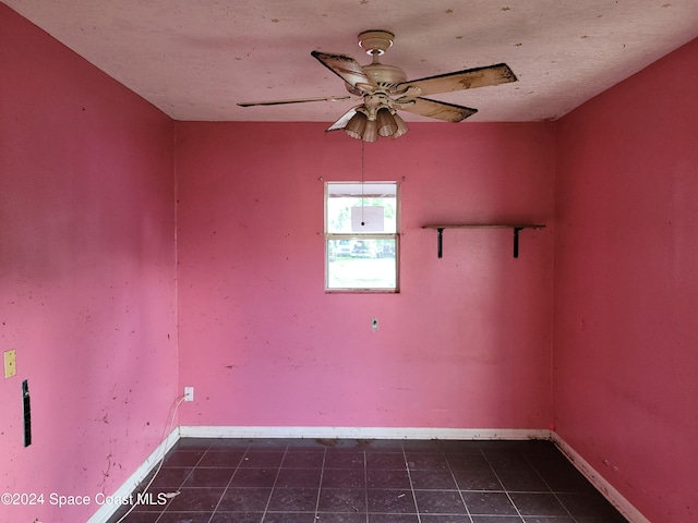 tiled spare room with ceiling fan