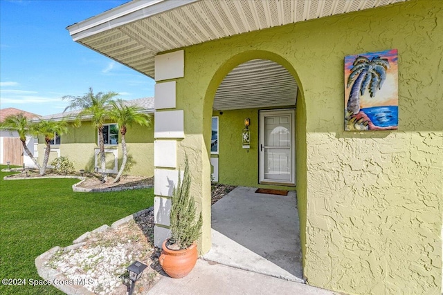 entrance to property featuring a yard