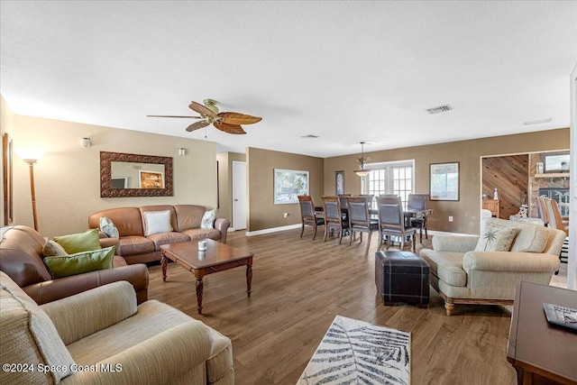 living room with ceiling fan and dark wood-type flooring