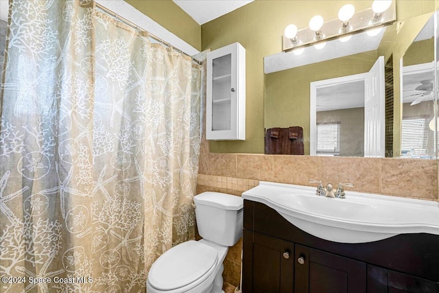 bathroom featuring vanity, toilet, tile walls, and ceiling fan