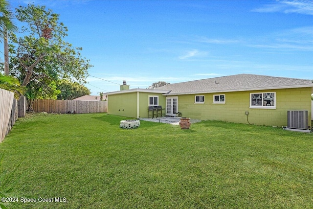 back of property featuring a lawn, central AC unit, and french doors