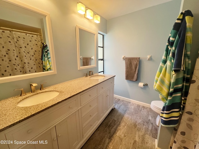 bathroom with hardwood / wood-style floors, vanity, and toilet