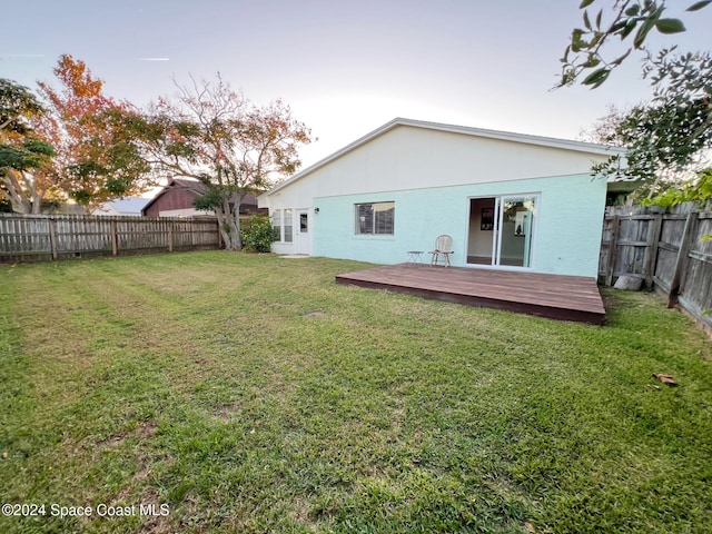 back of house with a yard and a wooden deck