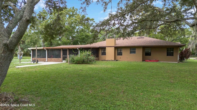 rear view of house featuring a sunroom and a yard