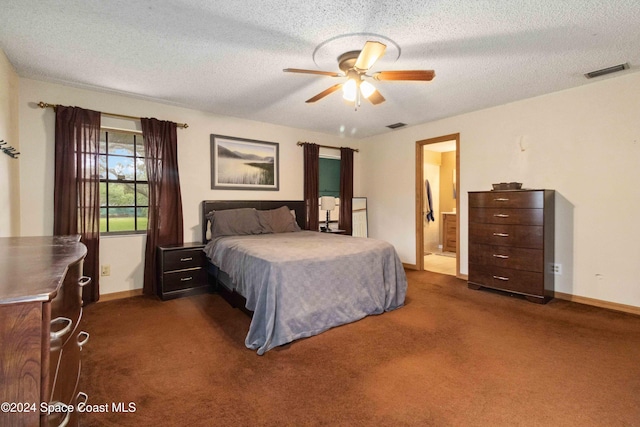 bedroom with dark colored carpet, a textured ceiling, ceiling fan, and connected bathroom