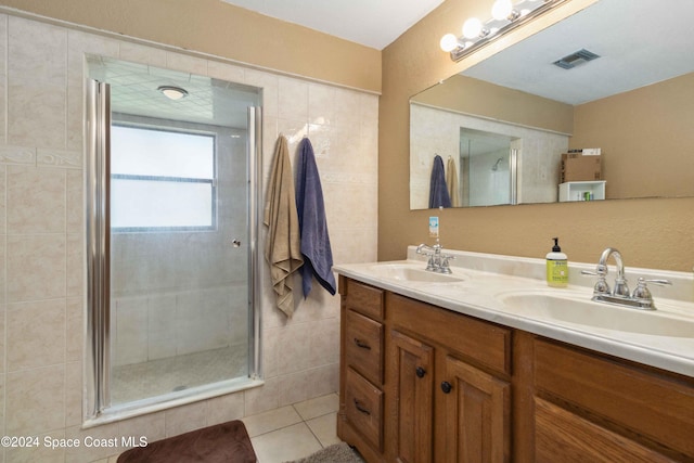 bathroom featuring tile patterned floors, vanity, an enclosed shower, and tile walls