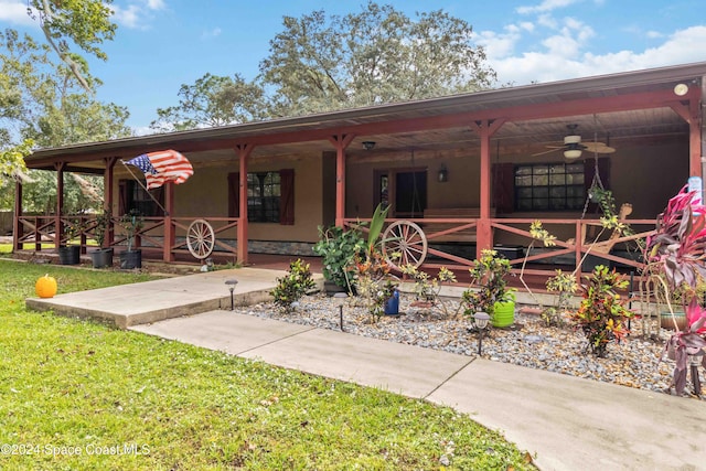 back of property with ceiling fan and covered porch