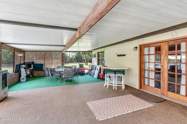 unfurnished sunroom with beamed ceiling