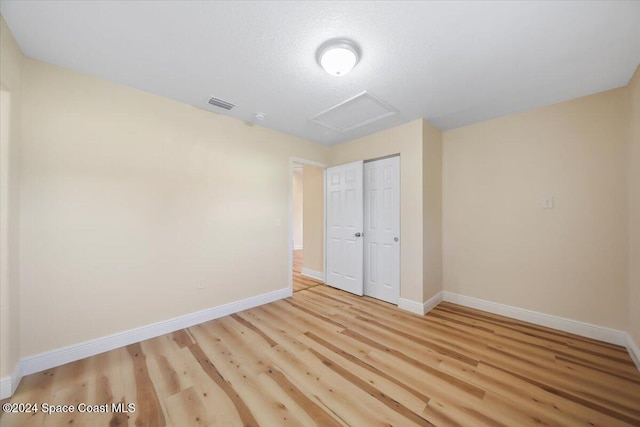 unfurnished bedroom with a closet and light hardwood / wood-style flooring