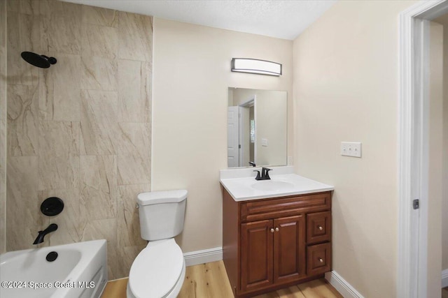 full bathroom featuring hardwood / wood-style flooring, vanity, toilet, and tiled shower / bath