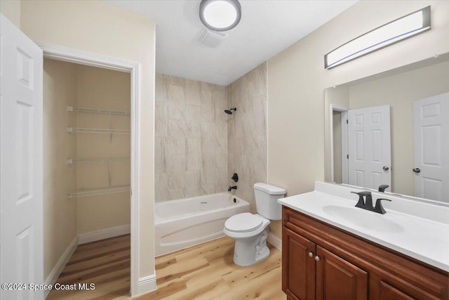 full bathroom with vanity, hardwood / wood-style flooring, toilet, and tiled shower / bath