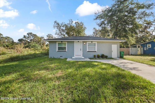 single story home featuring a front lawn