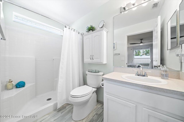 bathroom with walk in shower, vanity, ceiling fan, hardwood / wood-style floors, and toilet