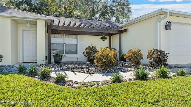 view of exterior entry featuring a yard and a garage