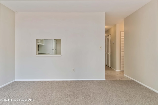 spare room featuring light carpet