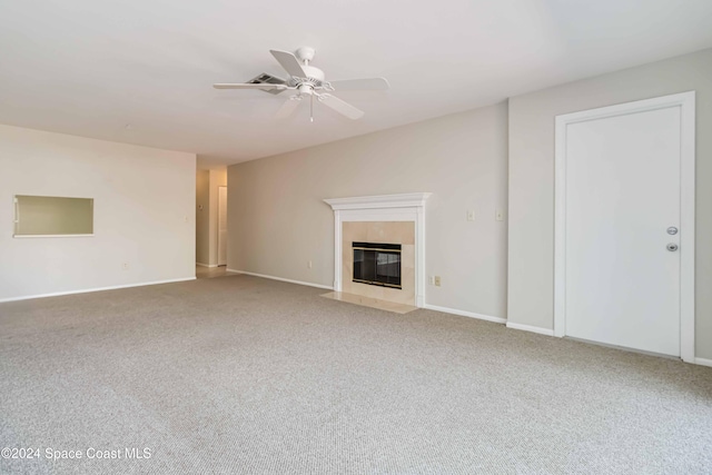 unfurnished living room with carpet, ceiling fan, and a tiled fireplace