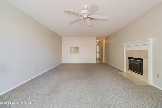 unfurnished living room with ceiling fan, a fireplace, and carpet