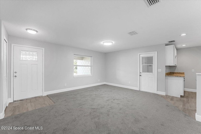 unfurnished living room featuring light colored carpet