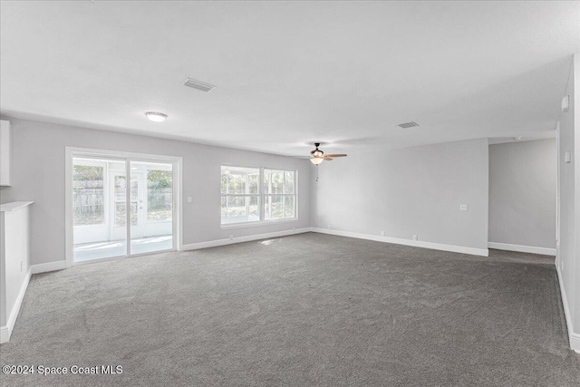 unfurnished living room featuring dark colored carpet and ceiling fan