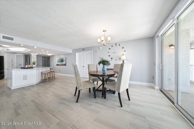 dining area featuring a chandelier and a textured ceiling