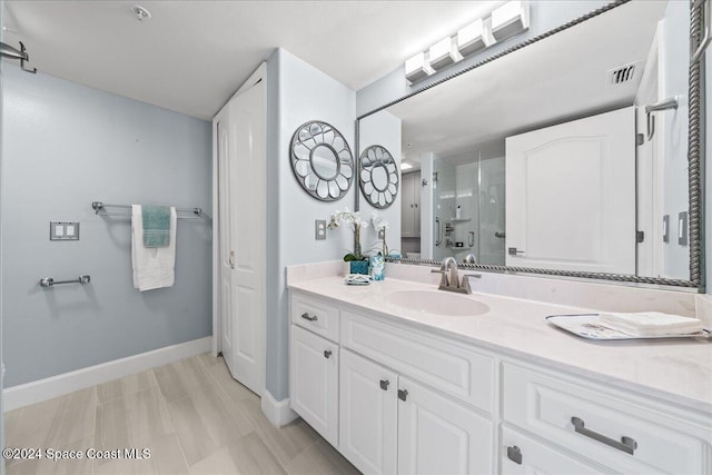 bathroom with a shower with door and vanity