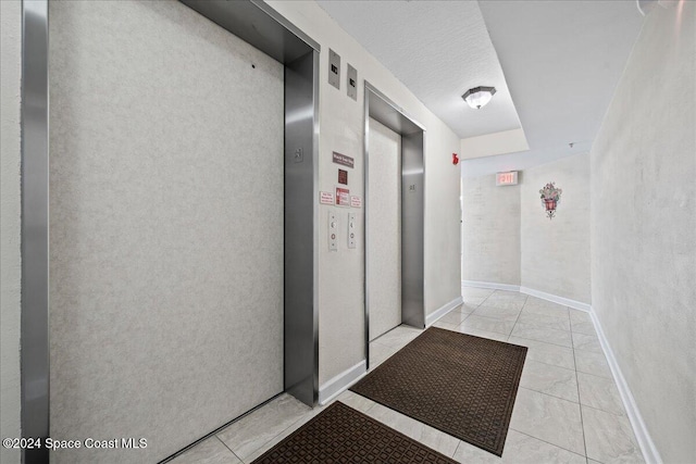 hallway with light tile patterned floors and elevator