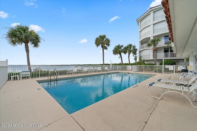 view of pool with a patio and a water view