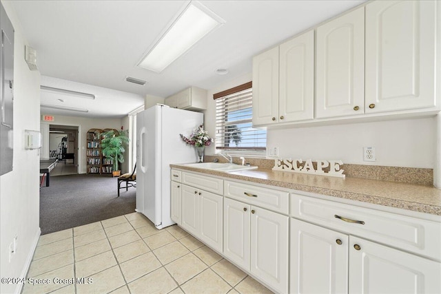 kitchen with white cabinets, white refrigerator, sink, and light carpet