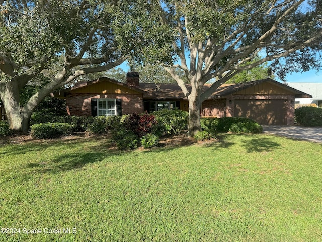 ranch-style house featuring a front lawn and a garage