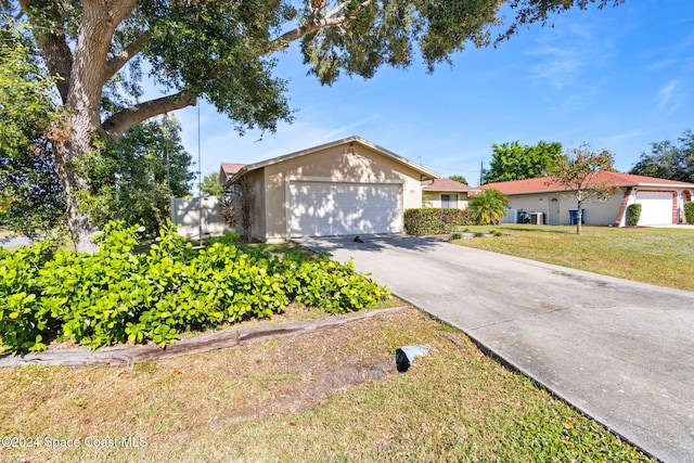 single story home with a front yard and a garage