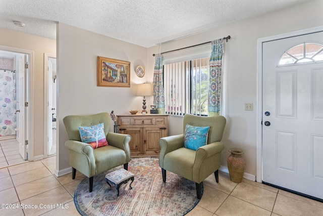 living area with light tile patterned flooring and a textured ceiling