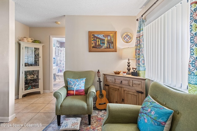 living area featuring light tile patterned floors and a textured ceiling