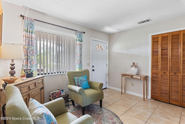 living area with light tile patterned floors and a textured ceiling