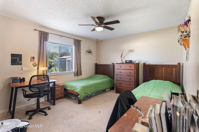 carpeted bedroom featuring ceiling fan and a textured ceiling